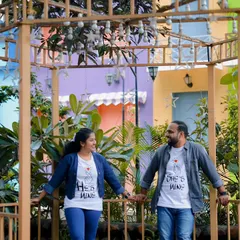A sweet moment in a colorful gazebo. The couple's matching t-shirts add a personal and fun touch to their pre-wedding photos.