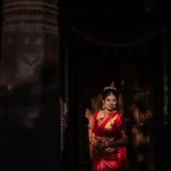 A dramatic bridal portrait using light and shadow. The bride is beautifully illuminated, creating a sense of mystery and elegance in this artistic shot.