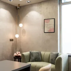 A cozy waiting area in a client's office, illuminated by our minimalist globe pendant. The light adds a touch of warmth and sophistication to the space.