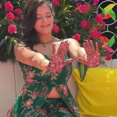 A fun, candid shot of a client enjoying her mehendi ceremony. The vibrant colors of her outfit and the decor make the henna pop.