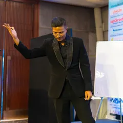 Every gesture on stage is part of the story. Here, I am setting up a mentalism routine for a corporate audience, building suspense before the final reveal.