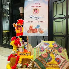 The entrance decor for Ritigya's first Lohri celebration. A personalized welcome sign, colorful umbrellas, and marigold flowers set a festive tone right from the start.