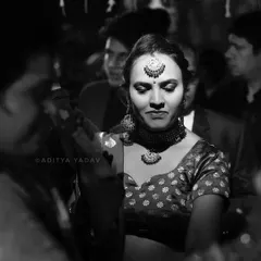 A candid black and white photo of a guest dancing during the sangeet or reception. The focus is on her expressive movement, capturing the joyful and energetic atmosphere of the celebration.