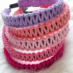 A colorful stack of my macrame hairbands, showcasing a variety of pink and purple shades. I use soft but sturdy cord to ensure they are comfortable enough for all-day wear, for both adults and children.