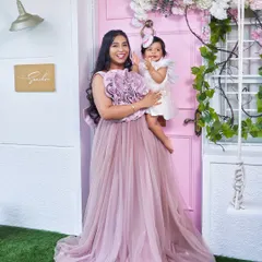A happy mother and her baby girl in our studio. The mom is wearing our mauve Bloom gown, which is also available in a matching "mommy and me" version.