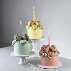 A trio of beautiful and elegant macaron cakes. Topped with macarons and delicate floral piping, these mini cakes are perfect for a sophisticated celebration or as individual gifts.