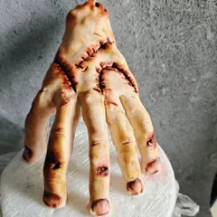 A close-up of the completely edible, hand-sculpted 'Thing' from my Wednesday Addams themed cake. Every stitch and detail is crafted from fondant.