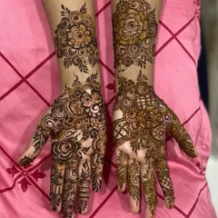 A beautiful example of asymmetrical floral design. Each hand features a different arrangement of bold rose motifs, creating a unique and modern bridal look.