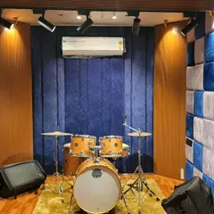 The drum corner in our live room, set up and ready to go. The checkered acoustic wall isn't just for looks; it helps control sound reflections, ensuring a tight and punchy drum recording.