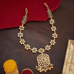 A delicate floral necklace set with white and green stones. The design features a chain of star-shaped flowers leading to a larger, ornate pendant with pearl drops, perfect for adding a touch of freshness to your look.