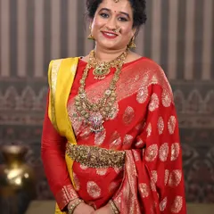 A close-up portrait that highlights the intricate details of the layered necklaces and the matching waist belt.