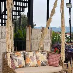 Swinging in boho style. This wicker swing, adorned with pampas grass and printed cushions, provides a perfect, relaxed photo opportunity.