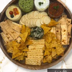 The ultimate Chip 'n' Dip Platter for any party. This board is loaded with an assortment of crackers, nachos, and lavash, surrounding a cheese ball and three of my signature dips.