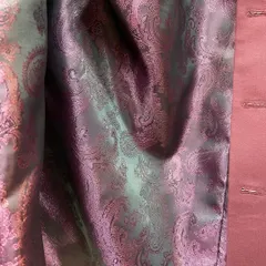 A close-up view of the custom inner lining selected for the maroon Nehru jacket. The iridescent silk with a paisley pattern shows how you can personalize even the hidden details of your outfit.