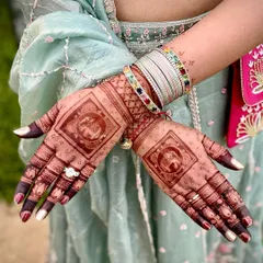 This design features a central square element with a traditional elephant motif, a symbol of good luck and prosperity. The fingers are tipped with dark henna for a classic bridal look.