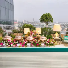 A beautiful rooftop buffet setup with the city skyline as a backdrop. The display combines our signature copper pots with fresh floral arrangements and ambient table lamps for a chic evening affair.