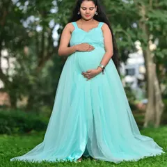 This light blue maternity gown is designed with a long, flowing trail to create stunning, ethereal photos. It's made from a lightweight net fabric that drapes beautifully.