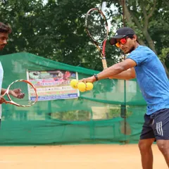 Technique is everything. We provide hands-on, personal instruction to break down every part of a shot, like this forehand grip and swing adjustment, to ensure our players develop a powerful and consistent game.