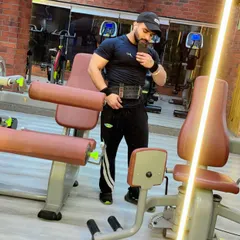Putting in the work and taking a moment to appreciate the results. This member is geared up with his lifting belt, ready for a heavy session, and capturing his progress.
