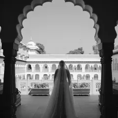 A moment of anticipation. This black and white silhouette of the bride against the palace courtyard creates a sense of drama and timeless beauty before her grand entrance.