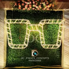 A creative selfie booth with a lush greenery wall and oversized, light-up sunglasses. This fun and trendy installation is guaranteed to be a hit with guests.