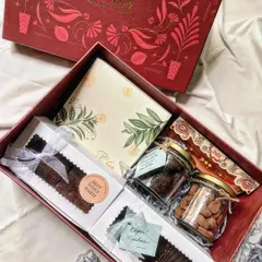 Our Premium Rakhi Hamper, elegantly packaged in a signature red box. It's filled with a box of 9 truffles, double chocolate brownies, Regal Riches, and jars of cookies and choco almonds, along with a Rakhi.