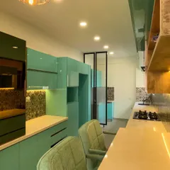 This view highlights the kitchen's built-in appliance unit and the seamless, handleless design of the lower cabinets. The layout ensures that everything is within easy reach for a smooth cooking experience.