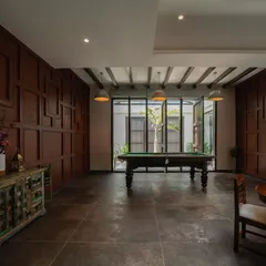 A rustic-themed game room featuring a pool table as the centerpiece. The room is paneled in rich, dark wood, creating a classic and warm atmosphere perfect for leisure and entertainment.