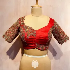 A frontal view of the red raw silk blouse with the wedding procession motif, showing the detailed floral embroidery on the sleeves.