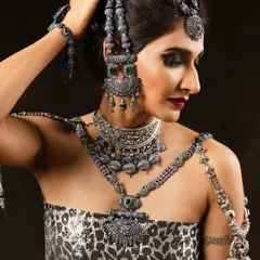 A slightly different crop that highlights the intricate details of the layered necklaces and earrings. The makeup remains bold to balance the statement jewellery.