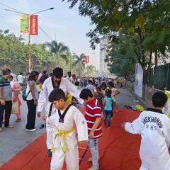 I'm guiding a young student through an agility ladder drill at a community event. These exercises are great for developing coordination and are fun for kids of all ages.