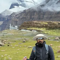 Standing before the south face of Kailash, equipped for the journey ahead. The path is rugged, but the spirit is willing, drawn by the immense presence of the mountain.