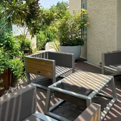 In this urban 'House of Terraces,' I used a minimal trellis to cast linear shadows, creating a dynamic play of light and shade. The custom outdoor furniture and lush planters transform this city space into a private, functional, and beautiful outdoor living room.