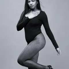 A black and white version of a model in a bodysuit, showcasing a soft and graceful pose.