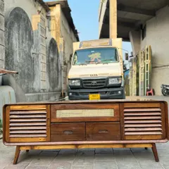 This media console combines multiple textures, including slatted doors, drawers, and a central cane-panelled section. It's a highly functional piece with a strong mid-century aesthetic.