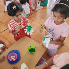 Children concentrate on painting paper cups to create unique crafts. This activity helps develop fine motor skills, patience, and the ability to follow multi-step instructions.