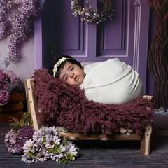 A beautiful, elaborate floral setup featuring a lavender-themed backdrop with a purple door and wisteria. This shows the level of detail and artistry I put into creating a completely unique and immersive set for your baby's photoshoot.