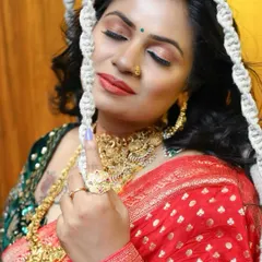 A close-up of the red Banarasi saree look, showcasing the rich gold jewelry and the detailed embroidery on the contrasting green blouse.