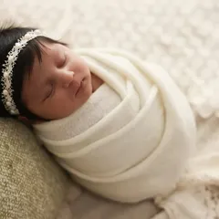 The perfect "Hello World" announcement. This classic newborn photo shows a peacefully sleeping baby swaddled snugly in a soft white blanket, looking pure and angelic.
