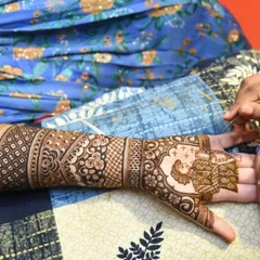 A candid shot of me applying a detailed bride portrait during a mehndi ceremony.