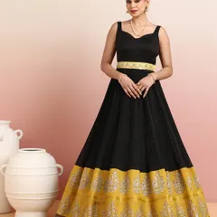 Elegance in every detail. This black pleated gown-style lehenga with its rich golden zari border exudes timeless sophistication. It is a perfect blend of modern chic and traditional artistry.