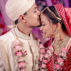A close-up of the groom kissing his bride's forehead, capturing the love and tenderness between them.