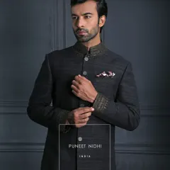 A closer look at the ash grey Matka silk Achkan, highlighting the jeweled collar and cuffs. The looped buttons trace the front with precision, a hallmark of my craft.