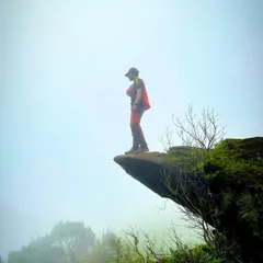Standing on a dramatic rock ledge in the foggy landscape of the Western Ghats. These treks offer incredible photo opportunities and a real sense of adventure.