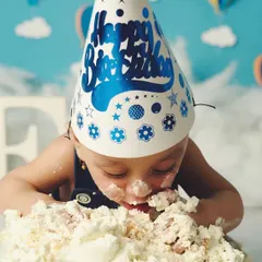 Diving right in. This photo captures the peak moment of a cake smash, showing the pure, uninhibited joy of the celebration.
