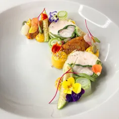 This is my Ballotine of fish, wrapped in Swiss Chard with a shrimp mousseline, yuzu pumpkin, and pickles. It's a dish that balances delicate flavors with complex technique, a true representation of my cooking style.