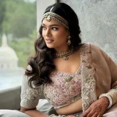 A soft and romantic open hairstyle for a daytime wedding. The gentle waves are complemented by a traditional matha patti, creating a look that is both modern and timeless.