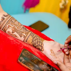 Here you can see me starting a new design, with the bride's arm resting on the traditional red cushion. The phone shows the design we are referencing.