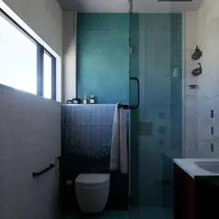 This concept for a bathroom uses a cool, moody color palette with deep teal tiles and a glass shower partition. The design focuses on creating a calm, enclosed space that feels both private and luxurious.
