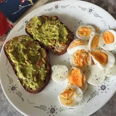 A breakfast designed to fight inflammation and fuel your day. This plate includes avocado toast on whole-grain bread with boiled eggs, providing healthy fats, protein, and complex carbs.